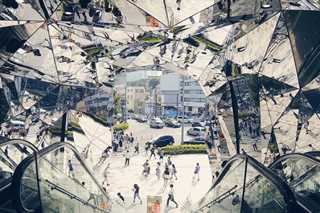 An escalator going down with mirrors on the walls and the ceiling. Photo.