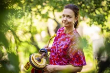 Maria Hansson in pink blouse in a garden. Photo.