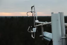Outdoor view of measuring equipment, sky and forest in the background. Photo.