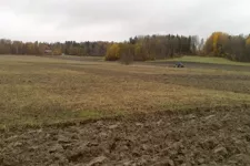 A field being plowed by a tractor. Photo.